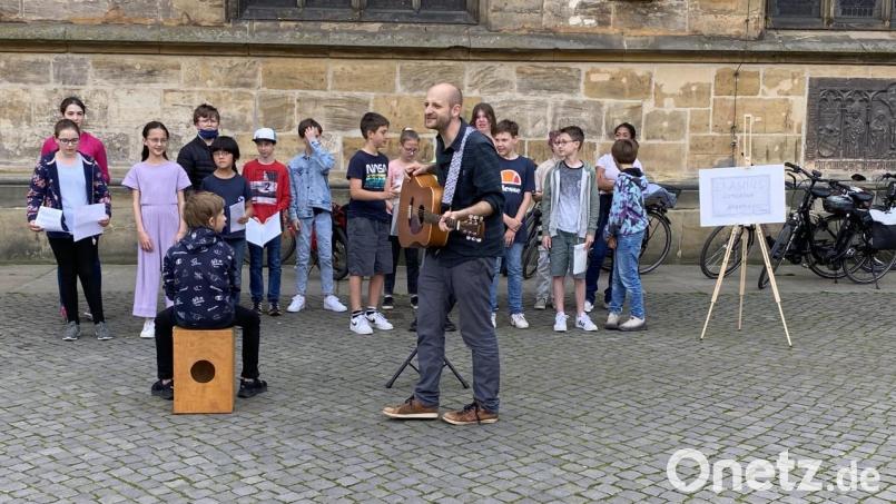 EG-Musiklehrer Sebastian Birner mit einem kleinen Auftritt des Unterstufen-Chors am Amberger Marktplatz. Bild: ero