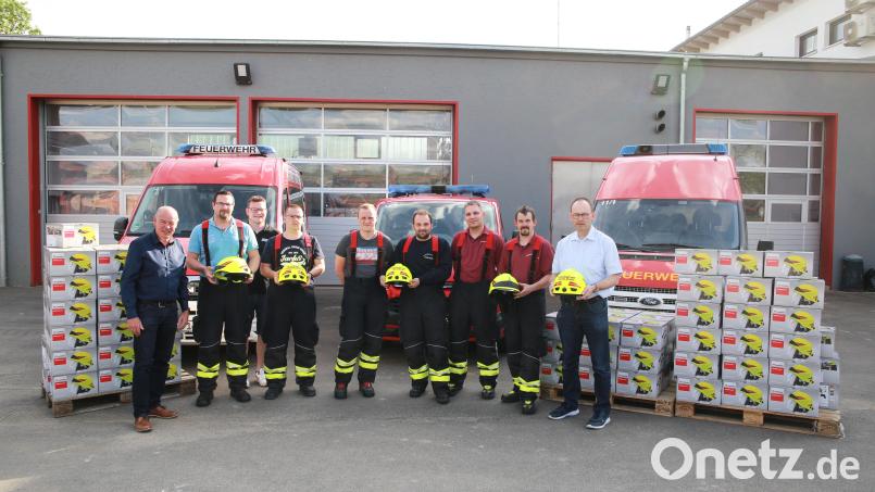 Bürgermeister Roland Strehl (links) und Hauptamtsleiter Wolfgang Roggenhofer (rechts) übergeben den Feuerwehren in der Gemeinde 160 Helme. Bild: egl