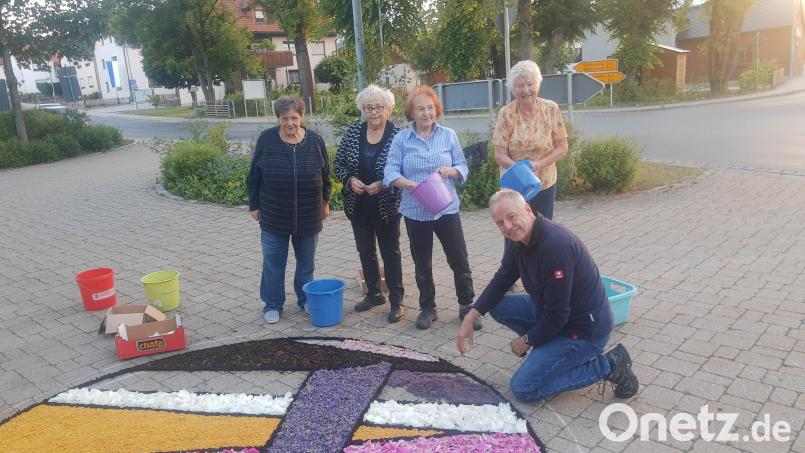 Else Erhardt, Annemarie Daubner und Gisela Reger (Zweite, Dritte und Vierte von links) lassen es sich auch im fortgeschrittenen Alter nicht nehmen, beim Legen des Blumenteppichs mitzuhelfen. Auf ihre langjährige Erfahrung möchte niemand verzichten. Bild: ld