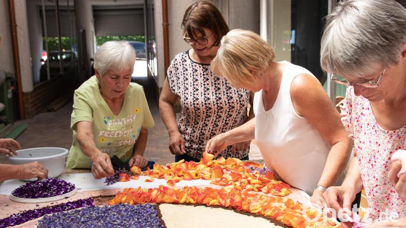 Emmi Helm, Elfriede Rosner, Marianne Gmeiner und Monika Mittereder (von links) vom Frauenbund Waldsassen platzieren Rosenblätter und Nelkenblütenblätter auf dem Blumenteppich. Bild: sfo