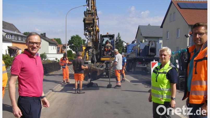 Voraussichtlich bis spätestens Freitag, 24. Juni kann die Pfaffenreuther Straße für den Verkehr freigegeben werden. Diese Woche ist mit der Asphaltierung der abgefrästen Abschnitte in der Fahrbahn begonnen worden. Vorne (von links) Bürgermeister Bernd Sommer, Petra Wick von der Planungsgruppe Steppan und Tobias Tippmann (Technisches Bauamt Stadt Waldsassen). Bild: pz
