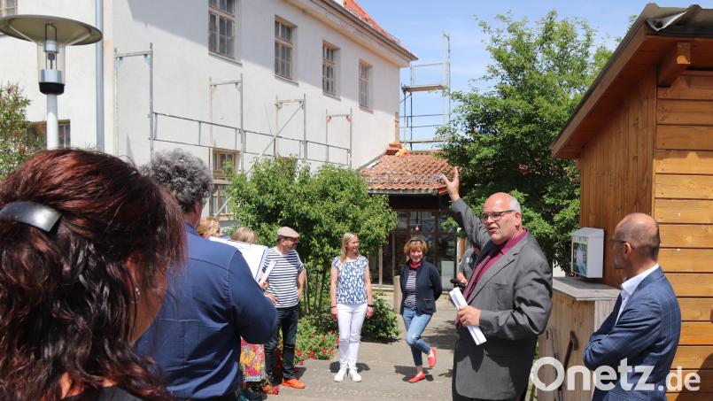 Bürgermeister Klaus Meyer zeigt dem Bewertungskomitee von &quot;Unser Dorf hat Zukunft&quot; das Badehaus in Maiersreuth, das das gleichnamige Kunstprojekt beherbergt. Susanne Neumann (Dritte von rechts), Annette Spreitzer (Vierte von rechts) und Axel Schmidt (Fünfter von rechts) sind mit vor Ort. Auch einige Anwohner begleiten den Dorfrundgang. Bild: sfo