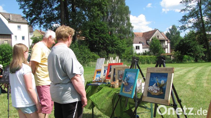Besucher bewundern die Kunstwerke der Malerinnen Dagmar Koller und Lisa Ucles-Bäumler bei der "Kunst an den Naabwiesen". Bild: sei