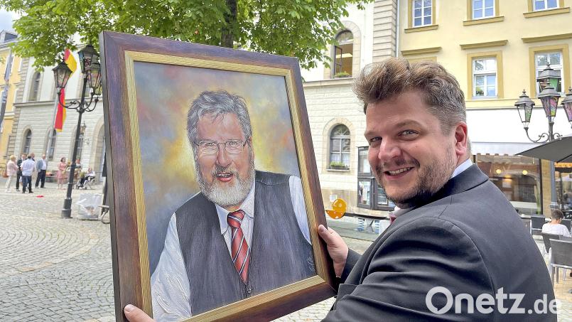 CSU-Ortsvorsitzender Aaron Grimm zeigt das Porträt von Altbürgermeister Karl-Willi Beck. Bild: Matthias Bäumler/fph
