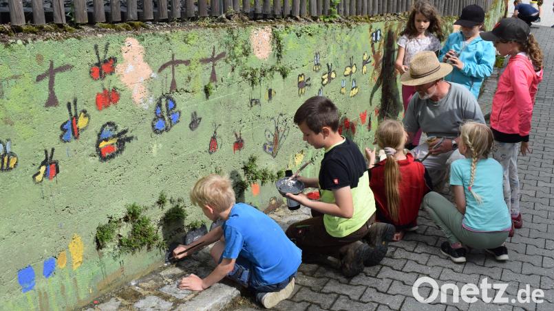 Mit Begeisterung bemalten die Schüler der Grundschule die Betonwand am Dorfladen. Angeleitet wurden sie dabei von Ernst Zimmerer. Bild: bnr