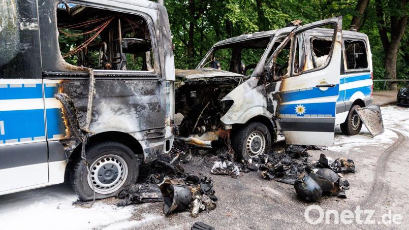 Zwei ausgebrannte Mannschaftsbusse der Polizei vor dem Hotel in München. Bild: Matthias Balk/dpa