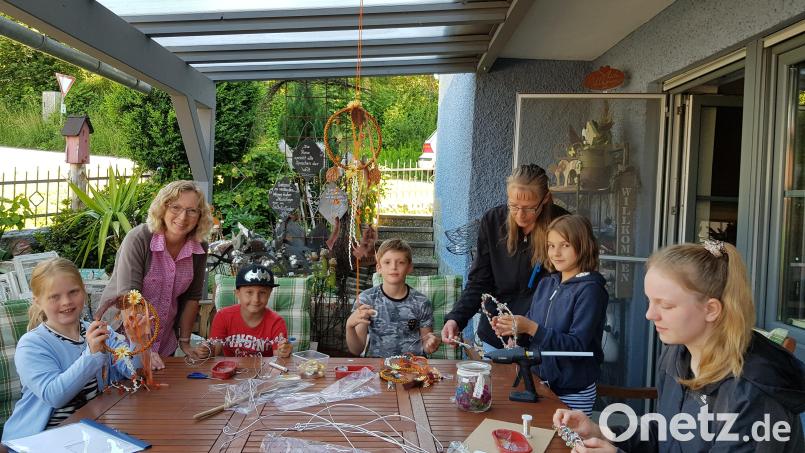 Mit viel Freude fertigen die Kinder Traumfänger und Perlendekorationen unter der Leitung von Angela Putzer (links). Bild: gi