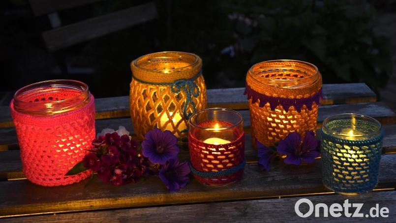 Mehrere Häkel-Windlichter in verschiedenen Größen und Farben sind ein besonders schöner Blickfang. Hier sind mittelgroße Marmeladen- und Milchreisgläser umfunktioniert worden. Die beiden kleinen Gläschen enthielten Desserts aus dem Discounter. Bild: Petra Hartl