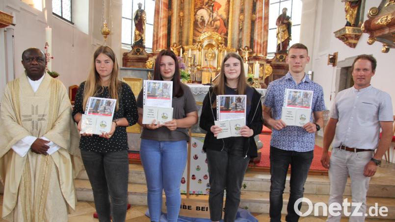 Pfarrer Dr. Charles Ifemeje und Pfarrgemeinderatssprecher Stefan Wurm dankten (von links) Sina Riedl, Lorena Witt, Antonia Hartmann und Maximilian Peter für ihre Ministrantentätigkeit. Bild: kro