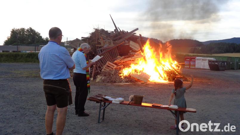 Pfarrer Eugen Wismeth betet vor dem Feuer und segnet es, assistiert von Alois Nesner. Bild: amö