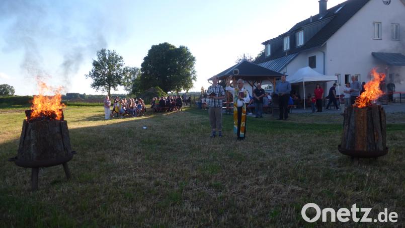 Die Geistlichen Matthias Weih und Varghese Puthenchira segnen das Johannisfeuer in Kaltenbrunn. Es musste aus Sicherheitsgründen auf zwei große Feuerkörbe reduziert werden. Bild: bk