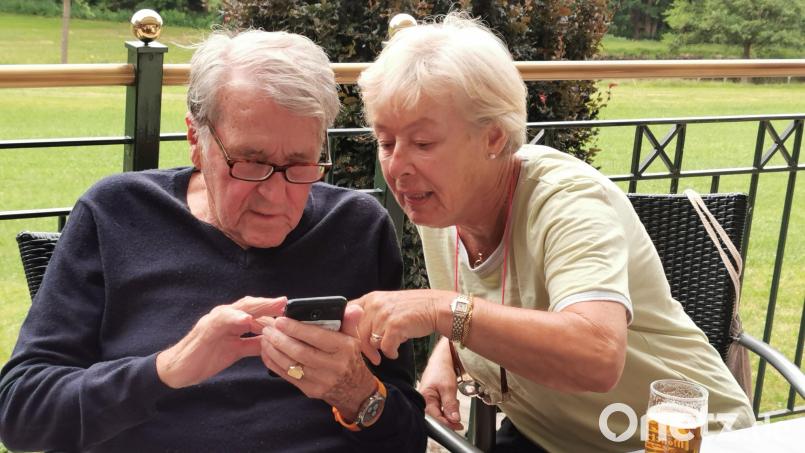 Der US-Amerikaner Johann Huber (90) sucht mit seiner Gattin Sigrid auf der Terrasse der &quot;Hammerschänke&quot; im Handy nach Schriftstücken zu seinen Vorfahren, die in der Greinerschleif bei Oberviechtach lebten. Bild: Portner