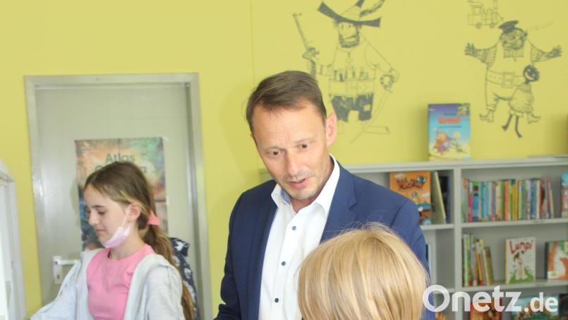 Oberbürgermeister Jens Meyer erkundet mit den Schülern die Bücherauswahl . Bild: Katja Zukanow/exb