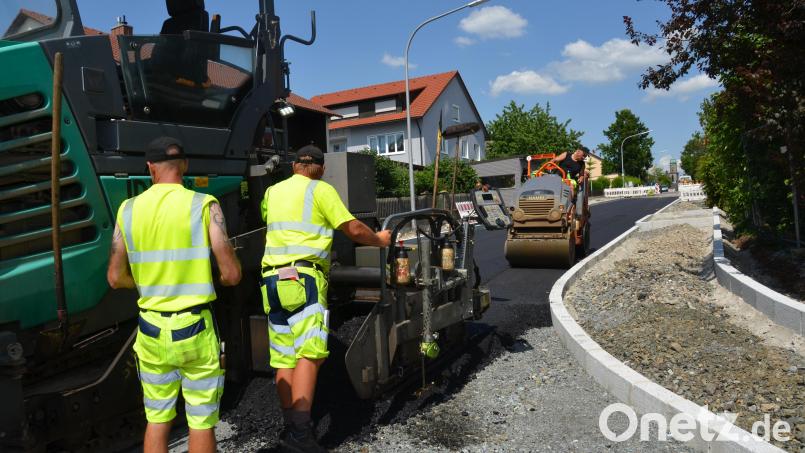 Die Straßenbauer der Firma Huber aus Rötz arbeiten bei 30 Grad Celsius mit der rund 180 Grad heißen Masse. Allerdings fließt der Schweiß in Strömen bei den Männern. Bild: dob