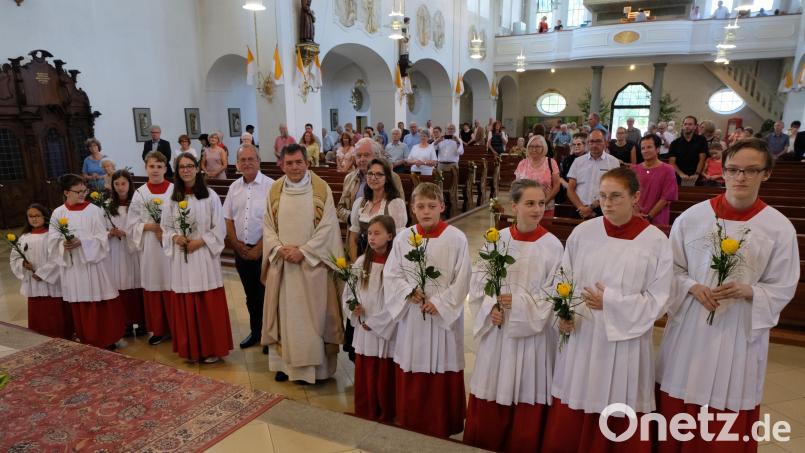 Ministranten mit Rosen, Pfarrgemeinderat und Kirchenpfleger gratulieren Pfarrer Max Früchtl, der vor genau 40 Jahren, am 26. Juni 1982 im Regensburger Dom durch Bischof Rudolf Graber zum Priester geweiht wurde. Bild: le