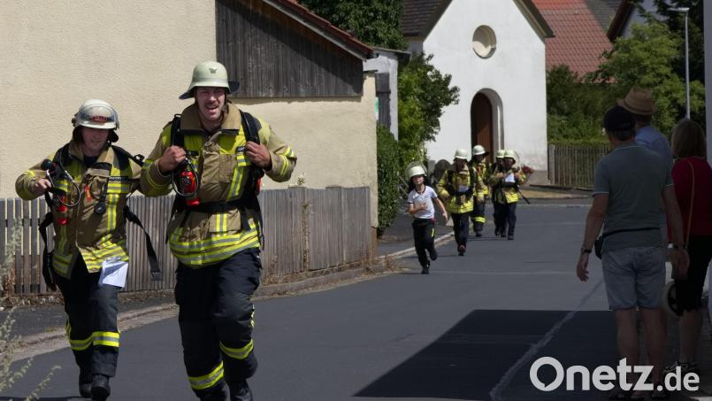 Mit schwerem Gerät und schwitzend für die gute Sache: Atemschutzgeräteträger bei ihrem Staffellauf während des Benefizlaufs der Ammersrichter Feuerwehr zu deren 125. Jubiläum. Bild: Wolfgang Weigl/exb