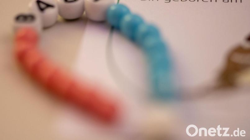 Ein Kettchen für ein Neugeborenes liegt im Kreißsaal einer Klinik. Symbolbild: Stefan Puchner/dpa