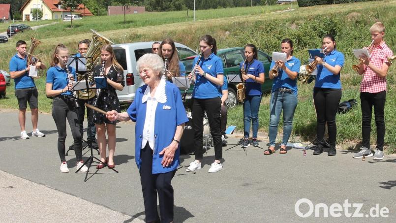 Irene Scheibl freut sich unter anderem über die musikalischen Glückwünsche des Musikvereins Waidhaus mit den Enkeln Kristina (Vierte von links, mit Kleid) und Michael (rechts, im karierten Hemd). Auch Zweiter Bürgermeister Rudolf Völkl gratuliert. Bild: pi