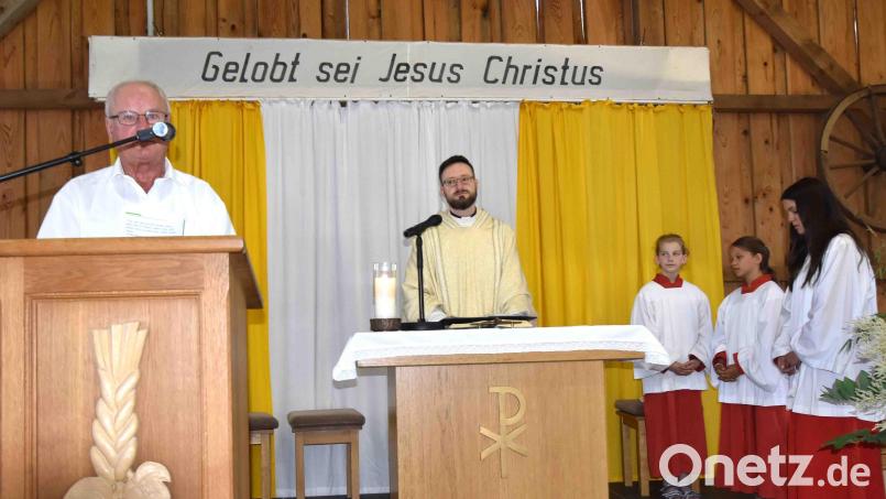 Fürbitten trägt der Vorsitzende des Kapellenbauvereins, Ludwig Hofmann (links), vor. Pfarrer Johannes Arweck feiert den Festgottesdienst im Dorfstadel. Bild: no