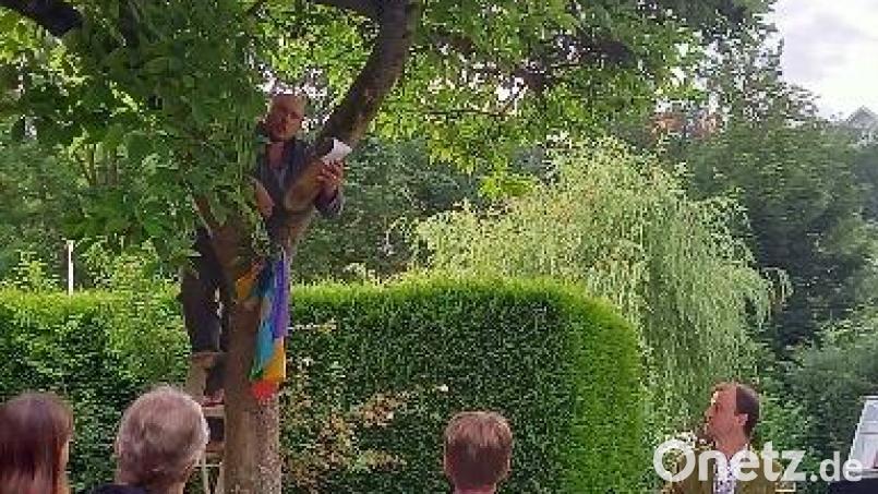 Sebastian Thomann trägt einen Text in luftiger Höhe auf einem Magnolienbaum vor. Bild: bjo