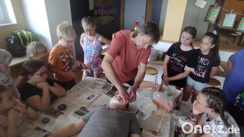 Stefan Link zeigt den Schülern das Auftragen der Gipsbinden Bild: amö