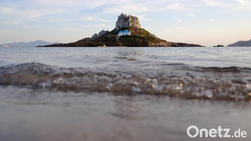 Sandstrand mit Traumblick: Vor Kefalos an der Südküste von Kos liegt die Insel Kastri mit der Kirche Agios Stefanos. Bild: Robert Michael/dpa-Zentralbild/dpa-tmn