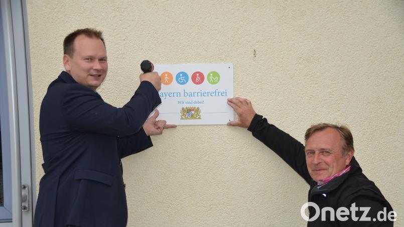 Die Gemeinde hat das Siegel für Barrierefreiheit an öffentlichen Gebäuden erhalten. Bürgermeister Christian Porsch (links) und Gemeindebehindertenbeauftragter Markus Vogel bringen dies am Rathaus an. Bild: ak