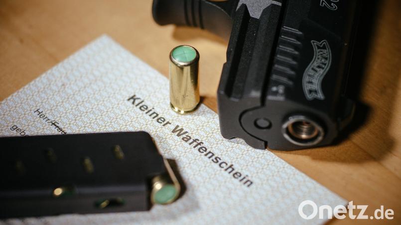 Ein Kleiner Waffenschein liegt zwischen einer Schreckschuss-Pistole, einem Magazin und einer Knallpatrone. Symbolbild: Oliver Killig