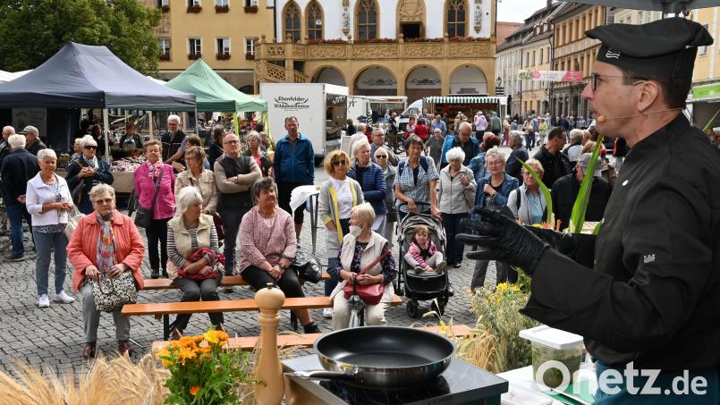 Christian Schliederer kochte am Freitag zum 30-Jährigen des Bauenrmarktes &quot;total regional&quot; zwischen den Ständen auf dem Marktplatz - umringt von vielen Interessierten, die natürlich auch probieren durften. Bild: gf