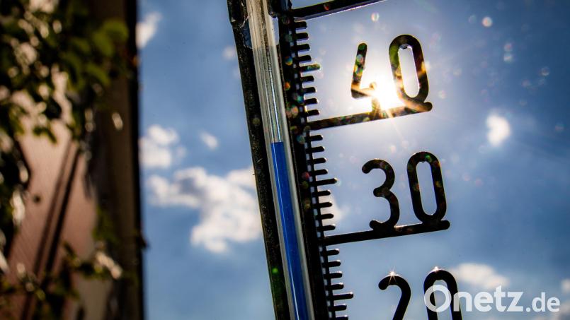 Ein Thermometer klettert in Richtung der 40-Grad-Marke.Die Belastung für die Bevölkerung durch hohe Temperaturen ist hoch. Symbolbild: Frank Rumpenhorst/dpa