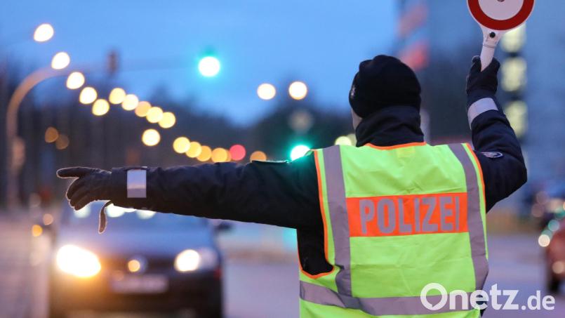 Ein Polizist hält ein Auto für eine Kontrolle an. Symbolbild: Bernd Wüstneck/dpa