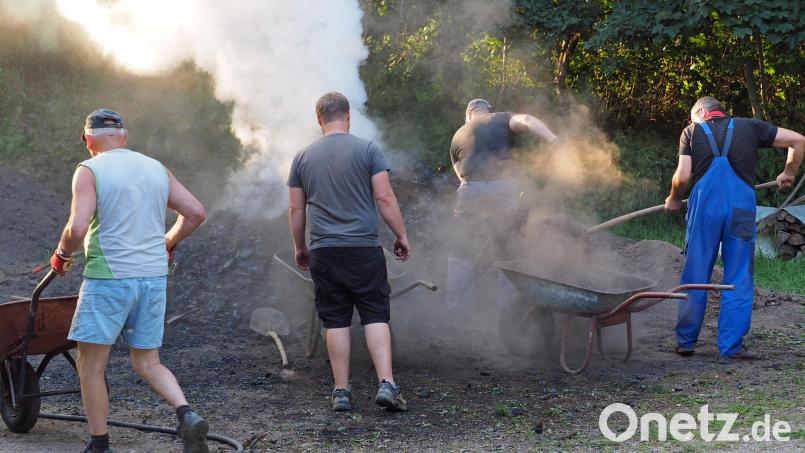 Die Köhlerfreunde bei schweißtreibenden Temperaturen am rauchenden Kohlenmeiler. Bild: wec