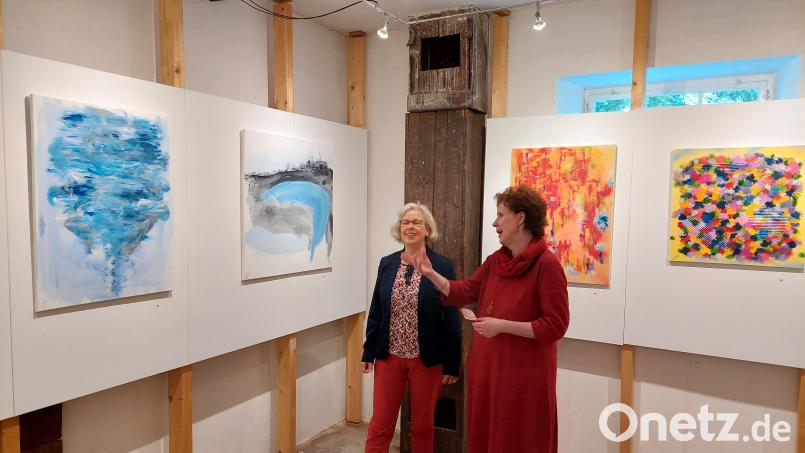 Susanne Kempf (rechts) bei der Vernissage im Gespräch mit Kuratorin Ronja Storch vom Fichtelgebirgsmuseum vor ihren Bildern „Der Mai ist gekommen“, „Freiz(h)eit“, „Schwungbremse“ und „Angemahnt / ermahnt“ (von links). Bild: kst