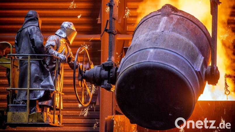 Arbeiter gießen flüssiges Eisen mit einer Temperatur von 1.400 Grad in der Eisengießerei Torgelow in vorbereitete Formen. Bild: Jens Büttner/dpa-Zentralbild/dpa