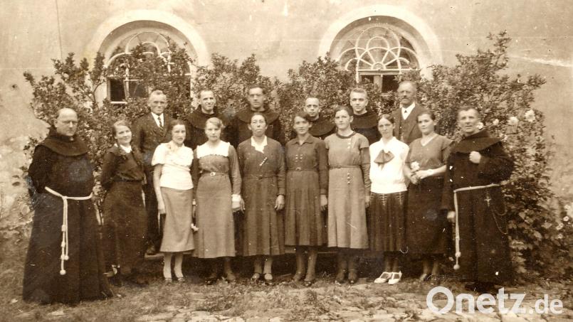 Pater Petrus (links) zeigt die historische Aufnahme mit dem Konvent und Klosterkirchenchor in Pfreimd 1933 Bild: Archiv Stadtturm Pfreimd/exb