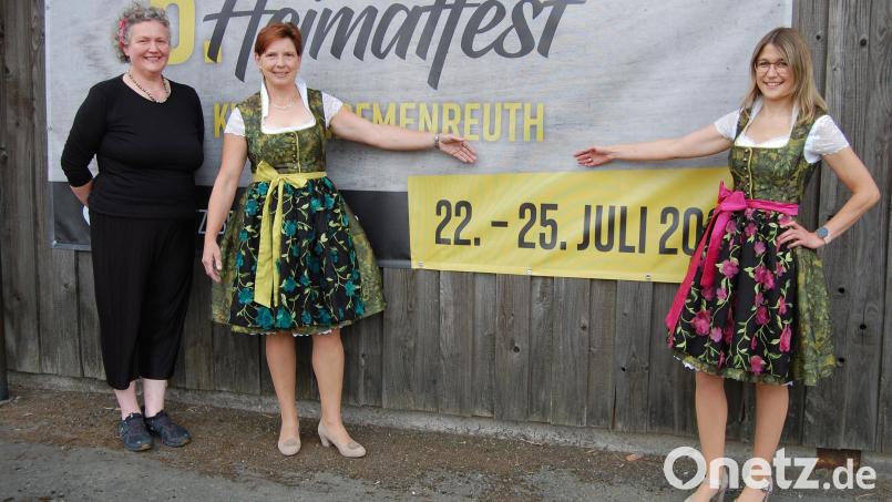 Schneidermeisterin Eva-Maria Enslein (links) hat 66 Dirndln für die Haberländer Festdamen entworfen und geschneidert. Die beiden Festdamen Tanja Bösl (Mitte) und Andrea Kandler (rechts) präsentieren die schicken Kleider schon mal vor dem Plakat zum Heimatfest. Bild: sm
