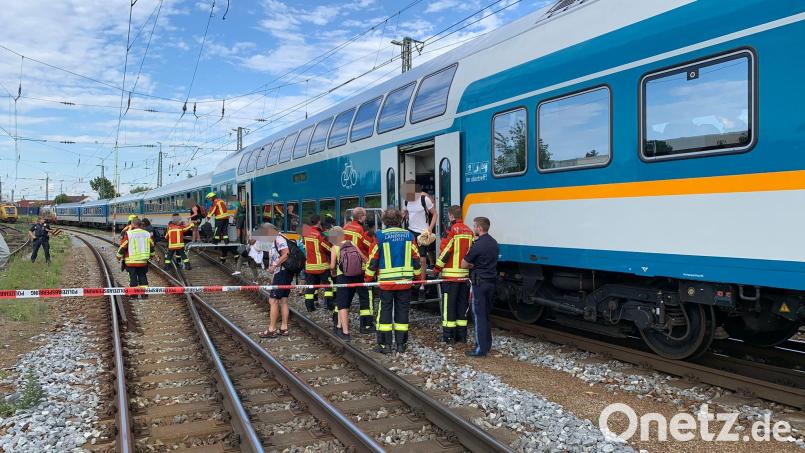 Fahrgäste verlassen einen liegengebliebenen Regionalzug beim Landshuter Hauptbahnhof. Bild: -/Freiwillige Feuerwehr Landshut/dpa