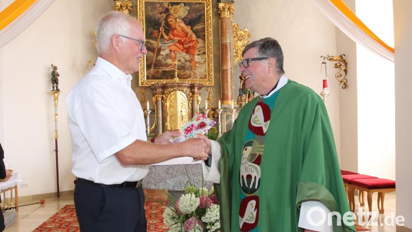 &quot;Vergelt&#039;s Gott&quot;, sagt Kirchenpfleger Josef Meckl und übergibt Monsignore Walter Wenninger einen Kirchenführer. Bild: pi
