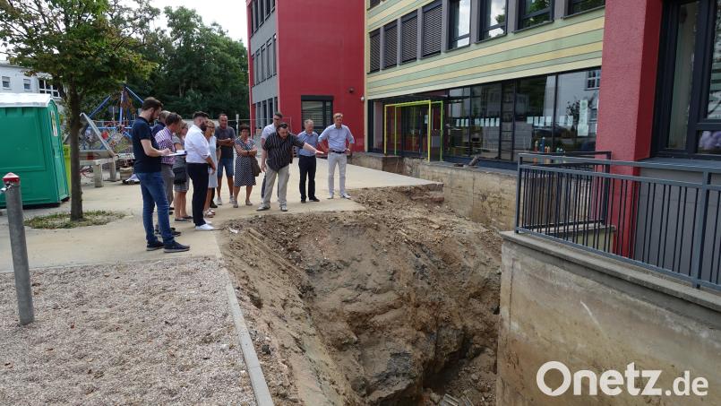 Der Neustädter Bauausschuss besichtigt die aufgegrabene Fassade der Grundschule. Bild: ui