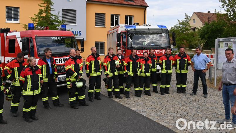 Vor dem Poppenrichter Rathaus waren die aktiven Feuerwehrdienstleistenden aus Poppenricht und Traßlberg angetreten, um ihre neuen Schutzanzüge vorzustellen. Rechts der Erste Bürgermeister Hermann Böhm sowie Berthold Kilian, der Geschäftsführer des Feuerwehrausstatters „fire &amp; safty“. Bild: gf