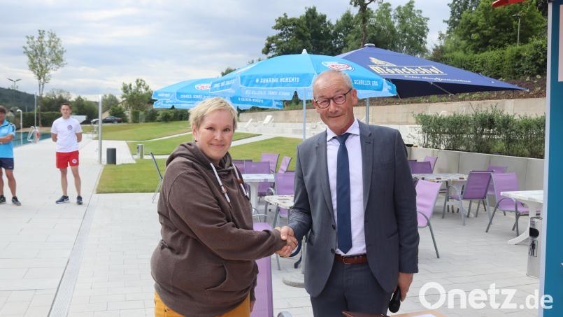 Bürgermeister Erwin Geitner gratuliert Basketballerin Anja Schmal zur Medaille. Sie darf sich ins Goldene Buch der Marktgemeinde eintragen. Bild: Michael Rabenhofer