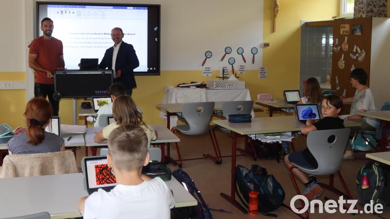 Schulverbandsvorsitzender Hans Ram (rechts) übergibt an die fünfte Klasse die neuen Laptops. Bild: mrr Michael Rabenhofer