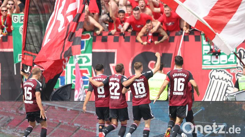 Der Nürnberger Manuel Wintzheimer (Zweiter von rechts) jubelt mit seinen Kollegen und den Fans über seinen Treffer zum 2:0. Bild: Daniel Karmann/dpa