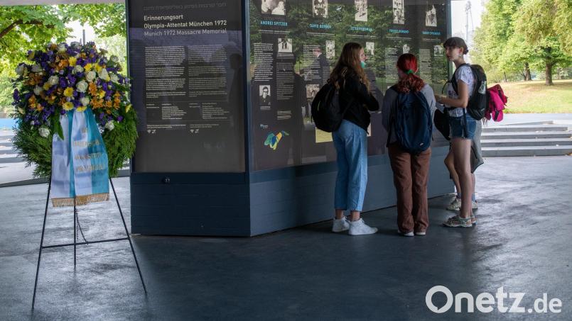 Am Erinnerungsort an die Opfer des Attentat bei den Olympischen Spielen 1972 stehen junge Frauen neben einem Kranz des bayerischen Ministerpräsidenten. Bild: Stefan Puchner