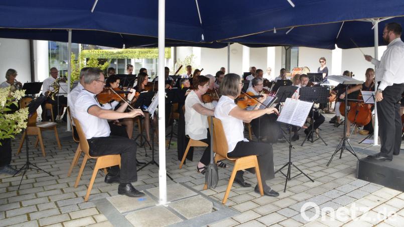 Gut beschirmt waren Orchester und Dirigent Jakob Johannes Schröder. Ein heftiger Regenguss bereitete dem Konzert dennoch ein jähes Ende. Bild: zch