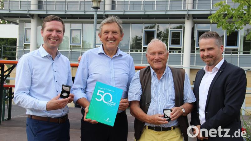 Landrat Florian Wiedemann (von links), die Altlandräte Hermann Hübner und Dr. Klaus-Günter Dietel sowie Euromint-Geschäftsführer Leif Burghard präsentieren das Landkreisbuch und die Sonderprägung „50 Jahre Landkreis Bayreuth“. Bild: Landratsamt Bayreuth/exb