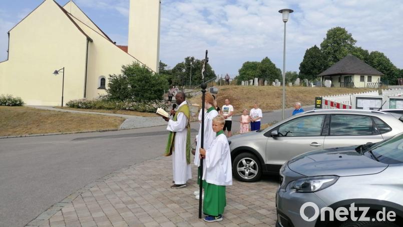 Pfarrer Charles Nwamiro ruft am Kirchparkplatz in Utzenhofen Gottes Segen auf die Fahrzeuge herab. Bild: aun