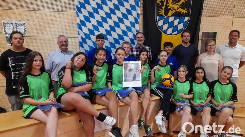 Mit dem Titel eines Bayerischen Vize-Meisters schmücken sich nun die Jungs und Mädels aus dem Dreifaltigkeits-Viertel zusammen mit Rektor Udo Leitz (hinten, Zweiter von links), Vertreter der Stadt Amberg Wolfgang Meier (hinten, Fünfter von links), Trainer Florian Birner (hinten, Dritter von rechts), Konrektorin Stefanie Löffler (hinten, Zweite von rechts) und Bezirksschulobmann Volleyball Markus Spörer (rechts). Bild: gel