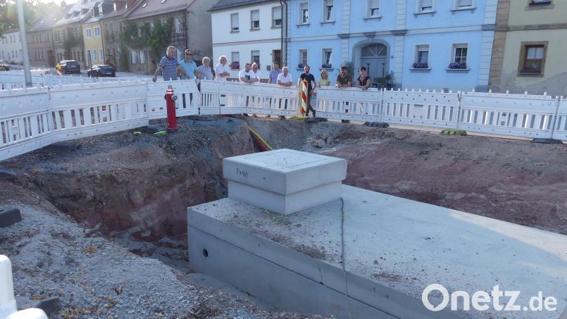 Bauleiter Daniel Färber erläutert den Stadträten bei ihrer Ortsbegehung auf dem Marktplatz unter anderem Sinn und Zweck dieser massiven Betonkonstruktion. Sie ist ein Vorratsbehälter für die Wasseraufbereitung eines Fontänenfelds. Bild: rn
