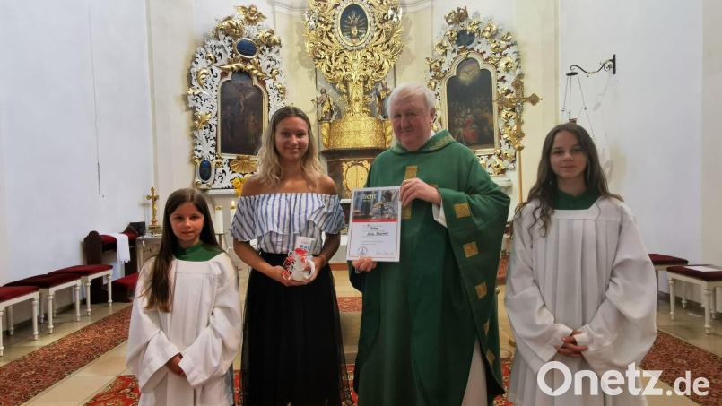 Pfarrer Erwin Bauer dankt der langjährigen Ministrantin Julia Bauriedl für ihren bewährten Dienst am Altar. Da nicht alle ausscheidenden Gottesdiener anwesend sein konnten, werden die Dankesworte und Urkunden nachgereicht. Bild: gz